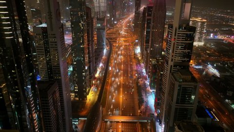 Aerial drone view at night of futuristic skyscraper buildings over Sheikh Zayed highway - Dubai - Dec 2021