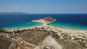 Aerial drone video of paradise turquoise sandy beach and bay of Simos in island of Elafonisos visited by yachts and sail boats, South Peloponnese, Lakonia, Greece