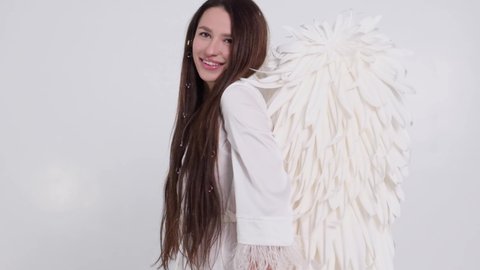 Slow motion, girl with angel wings on a white background. 