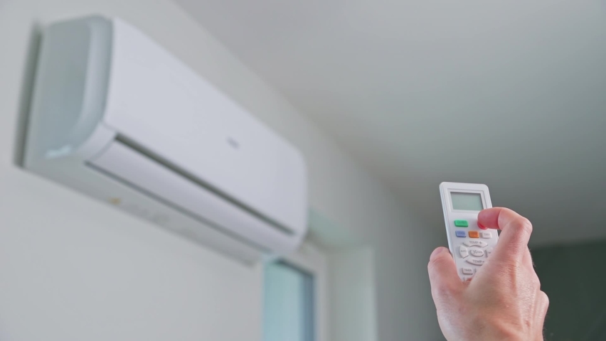 Hand adjusting temperature on air conditioner with remote control, Working air conditioner for comfort temperature in home at hot summer Royalty-Free Stock Footage #1085674289