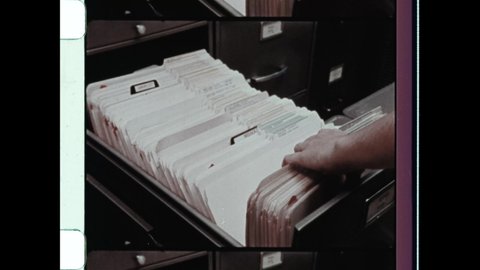 1960s Washington, DC. Close up of Female hands collating documents. Close up of Woman filing archived documents in metal filing cabinet. 4K Overscan of Vintage Archival 16mm Film Print