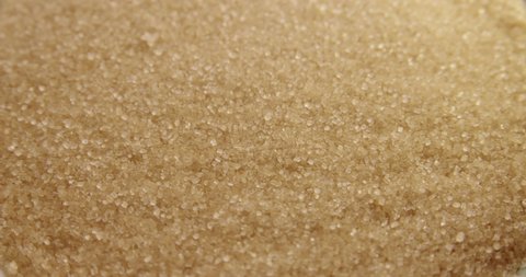 Close up of brown sugar texture. Cane sugar as a background. Sugar falling.