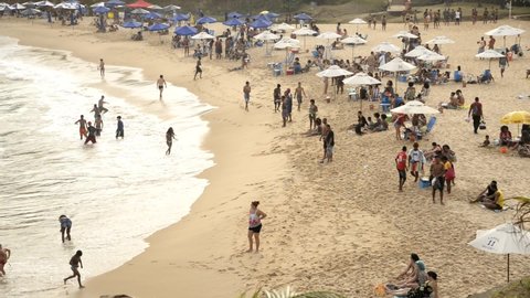 Salvador, Bahia, Brazil - August 22, 2021: People on the beach playing and bathing in the sea. Praia da Paciencia on the Rio Vermelho in Salvador, Bahia, Brazil.
