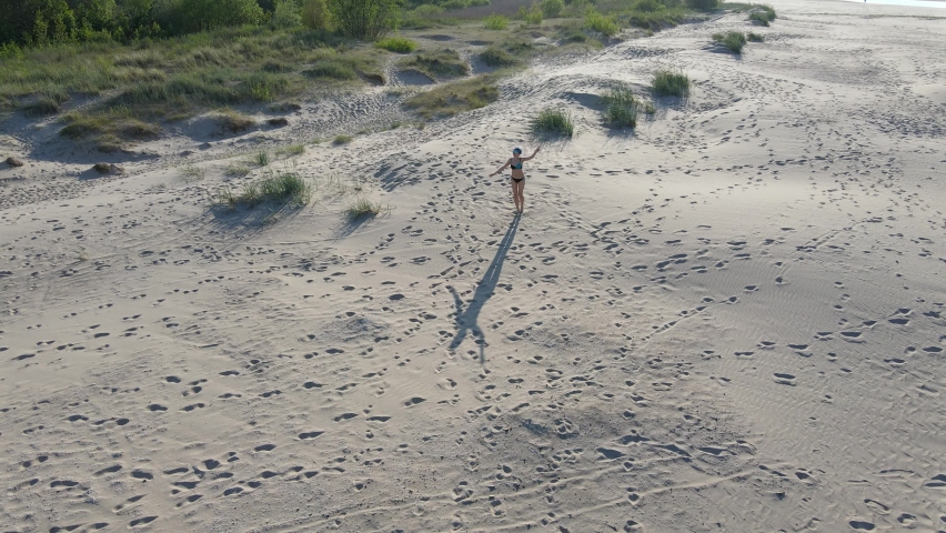 Joyful beautiful happy beach bikini woman running, freedom girl relaxing on sand, sea landscape and nature. Vacation, freedom concept. Runner in Drone Aerial View | Shutterstock HD Video #1085684426