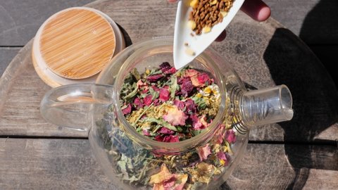 herbal teas in transparent glass pot, dries herbs, flowers. Healthy antioxidant hot drink