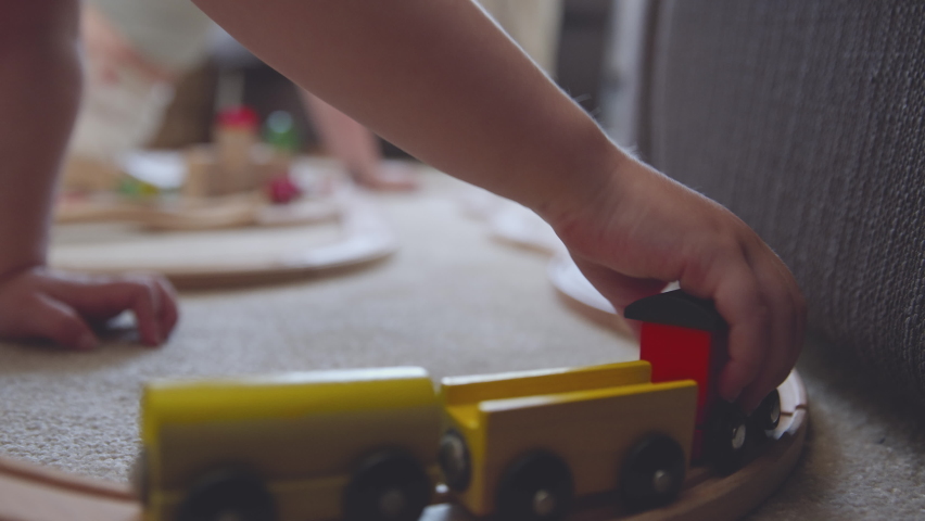 Close Up Of Mother And Daughter At Home Playing With Wooden Train Set Toy On Carpet