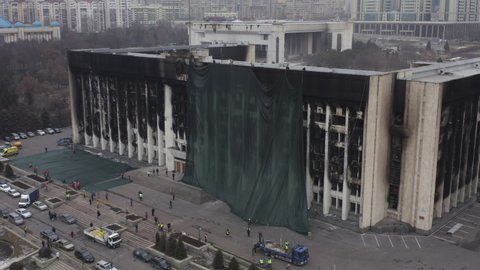 Almaty, Kazakhstan - January 11, 2022: The burnt building of the city administration after the protests in Almaty. Covering a burnt building facade for renovation after terrorist attack.