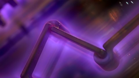 A metal structure in a vacuum and a beautiful mesmerizing plasma glow that has formed around the object. Shot in motion. Closeup