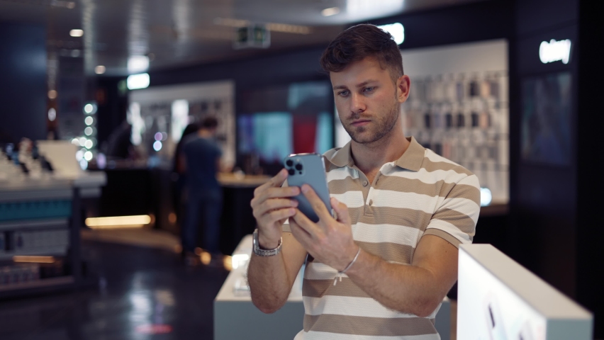 Man choosing smartphone in modern shop