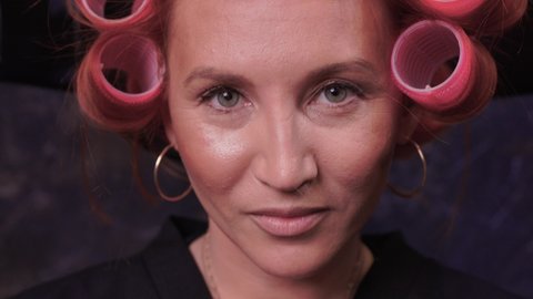 Closeup of red hair during hair dressing with curler.
