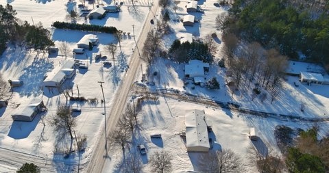 Aerial view of a winter time snowy day in American town of showing rows houses with snow covered roofs