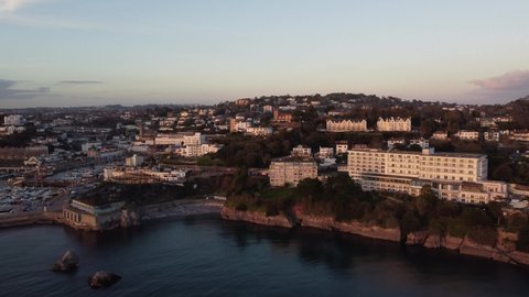 Torquay, Devon, England: Drone, high angle tracking shot of the marina, town and buildings on a winter's evening (MUTE)