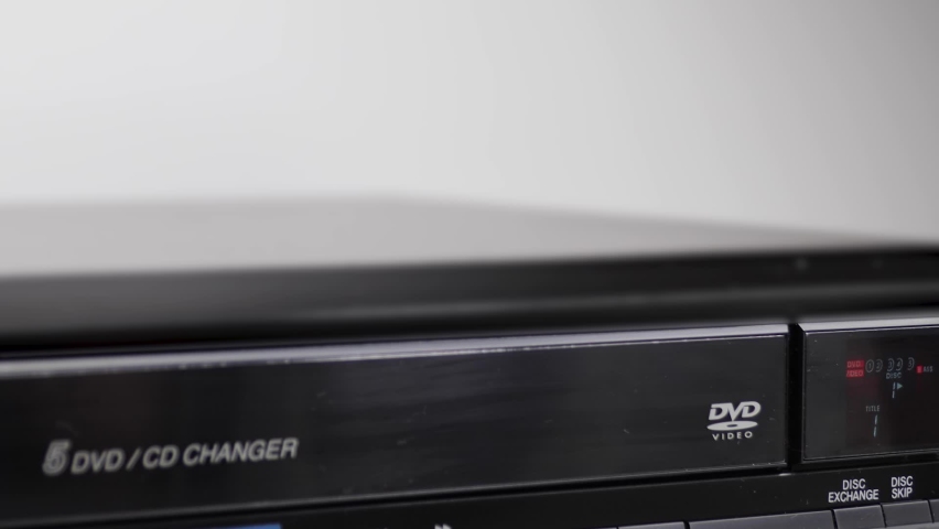 A vintage DVD drawer opening with DVD disk in tray white background