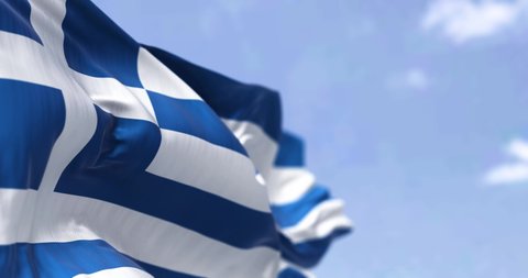 Detail of the national flag of Greece waving in the wind on a clear day. Democracy and politics. European country. Patriotism. Selective focus. Seamless Slow motion