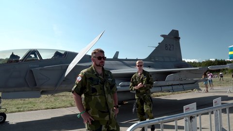 Gdynia , Poland - 08 22 2021: Pilot of Swedish Air Force In Military Uniform Standing Outside The Saab JAS 39 Gripen Aircraft 