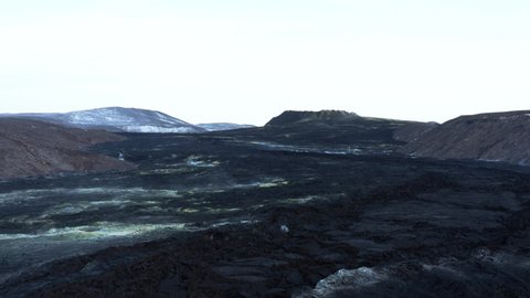 Large solid black lava field in Fagradalsfjall valley, distant dormant Geldingadalsgos volcano