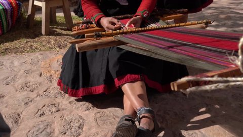 Peruvian Weaves Multi-colored Fabrics in Sacred Valley, Peru - tilt up shot