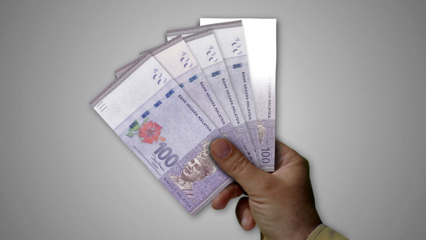 Malaysia Ringgit paper note holding. Fan of MYR banknotes in hand. Metaphor concept of income loss, cost of live, tax, credits and money decline. | Shutterstock HD Video #1085728070