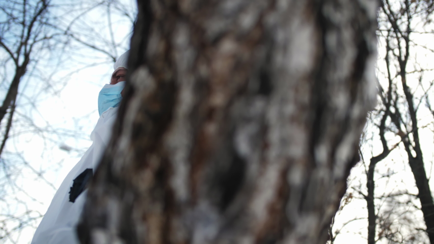 A close-up of a man sitting in a tree and waving his legs.