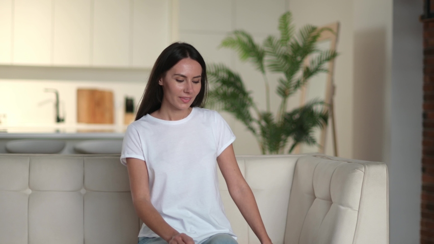 Upset frustrated caucasian young adult woman suffering from backache, unhappy brunette sit on a sofa in living room, trying stands up, feels discomfort because of pain in back, need treatment and rest Royalty-Free Stock Footage #1085734529