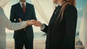 Close Up of Female Queer Couple Exchange Rings and Kiss at Outdoors Wedding Ceremony Near Sea. Happy Two Lesbian Women in Love Say Their Vows and Get Married. LGBTQ Relationship Goals. - Powered by Shutterstock - Get 15% off with code: PIKWIZARD15