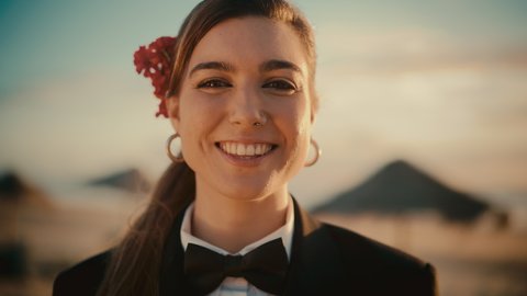 Portrait of a Happy Young Adult Woman Wearing a Stylish Suit, Bow Tie, Nose Ring and Decorative Flower is Posing for Camera. Beautiful Multiethnic Caucasian Woman Smiling. Warm Color Edit.