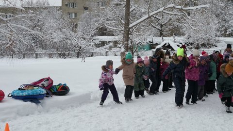 Saratov, Russia - Jan,2022: Kids celebrate Maslenitsa Pancake week - purely Russian Holiday. People eat pancakes, play folk games, have fun letting long winter out.