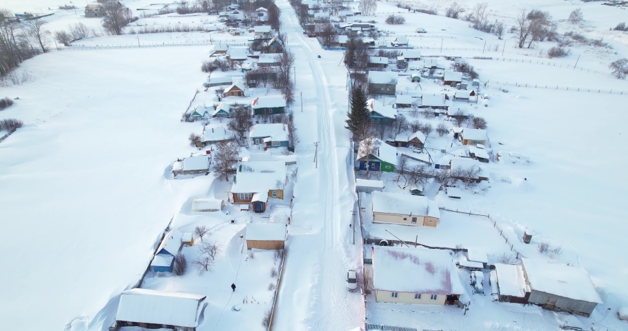 Aerial view of a winter village in Russia. Snow-covered roads on the streets of the village.