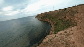 FPV flight over a coastal cliff at cloudy day