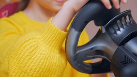 Girl driving a game wheel closeup