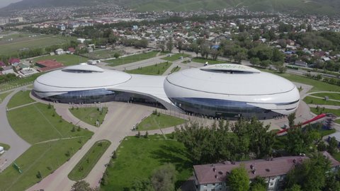 Almaty, Kazakhstan - May 6, 2020: Flight over Halyk Arena on a bright sunny summer day. New sports facility in the city of Almaty. Wide aerial footage of two stadiums of Halyk Arena.