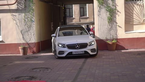 SAINT-PETERSBURG, RUSSIA - JUNE, 6, 2021: White luxury car driving in summer city. Mercedes-Benz E-class w213 automobile drive in to red carpet for party. Vip passengers transportation or wedding.