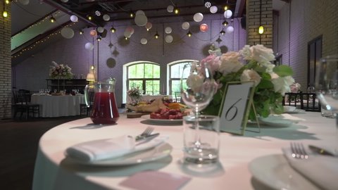 PETERSBURG, RUSSIA - JUNE, 11, 2021: Served table in restaurant for dinner celebration. White tablecloth, plates, napkins and glasses, chairs. Holiday indoors. No people and food. Decorated wedding.