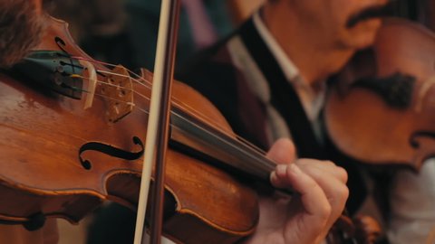 Close-up of a beautiful violin played by girl in slow motion. Beautiful young woman, man musician playing the violin. orchestra rehearsal. violinist plays violin at orchestra rehearsal