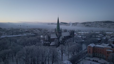 Flying Towards The Nidaros Cathedral With Winter Landscape In Trondheim City, Trondelag, Norway. - aerial approach