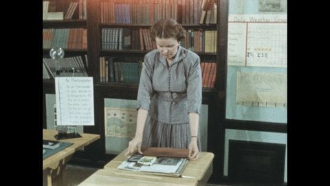 1950s: Woman gathers photos into folder and walks from desk. Hands remove photos, papers and ephemera from folder.