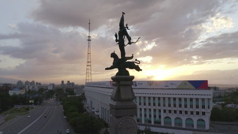 Almaty, Kazakhstan - May 3, 2020: Statue of the Golden Man on the Republic Square in Almaty. Aerial view of Altyn Adam monument on the central square at sunset.