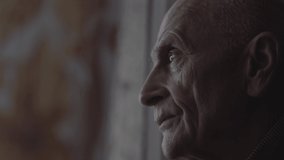 Adult male person looking through window of nursing house and waiting of visitors. - Powered by Shutterstock - Get 15% off with code: PIKWIZARD15