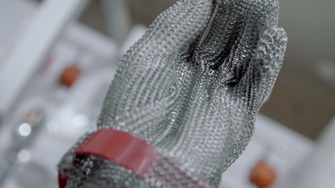New 5-fingered metal chainmail glove with cuff for butcher's. Shot in motion. Closeup