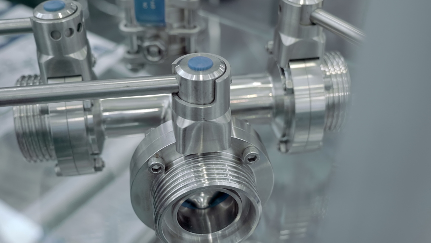 Modern stainless steel industrial ball valves with blue lever used in the food industry. Shot in motion. Closeup Royalty-Free Stock Footage #1085748548