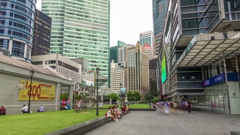 SINGAPORE - CIRCA JAN 2020: Skyscrapers and towers at Raffles Place in Singapore Financial Centre timelapse hyperlapse. Green lawn. People walking around