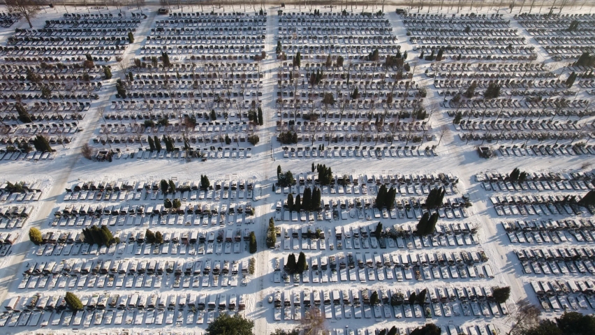 Aerial backward flight over the huge cemetery with rows of graves covered with fresh snow - covid-19 mortality concept Royalty-Free Stock Footage #1085758457