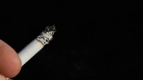 Man hand while smoking cigarette,tobacco smoke addiction,unhealthy lifestyle,slow motion