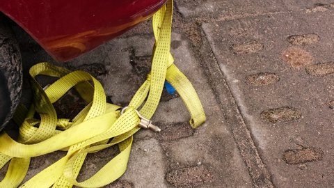 Vehicle Yellow Tow Strap Tape Line with Screw Hitch Towing Hook Attached to Front of Broken Car