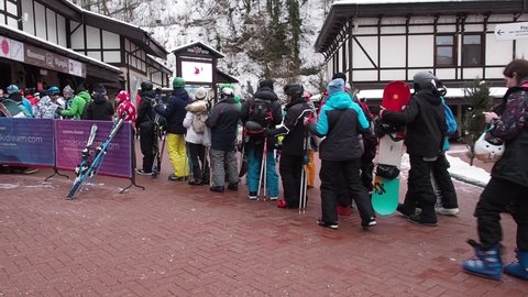 Sochi, Russia, February 05, 2020: The queue for the cable car Olympia on ski resort Rosa Khutor. Many people of skiers and snowboarders stand in a long line due to closed slopes during heavy snow.
