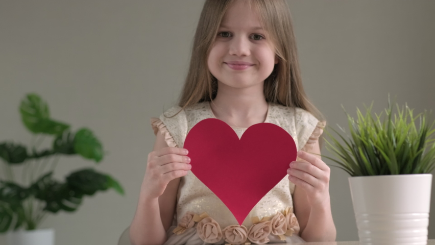 Cute little girl smiling giving big handmade paper red heart for Valentines Day. Happy child with present. Mothers or fathers day, DIY concept Royalty-Free Stock Footage #1085766284