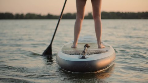 Travel Paddles Paddleboard. Sup Board Journey. Young Woman Relaxing On Sup Surf Swimming. Watersport Floating On Surfboard At Sunset. Girl Stand Up Paddle Boarding. Warm Summer Beach Vacation Holiday