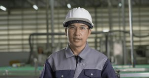 Portrait of male engineer at modern factory. He talking to team and looking to camera. Industry, Engineer and Business concept.