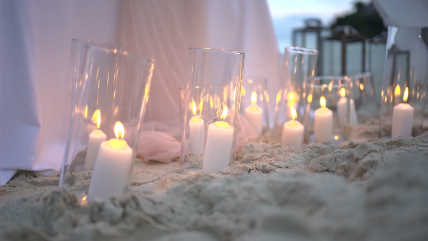 Candlelight bright decoration on sandy beach during sunset. Romantic setting table dinner.  | Shutterstock HD Video #1085775278