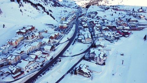 Moving 4K drone flight over the skiing resort village Obertauern in Austria during high season in winter with lots of snow